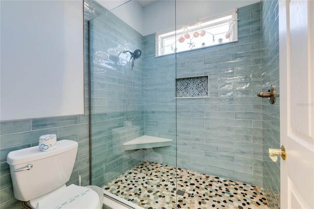 full bathroom featuring tile walls, toilet, and tiled shower