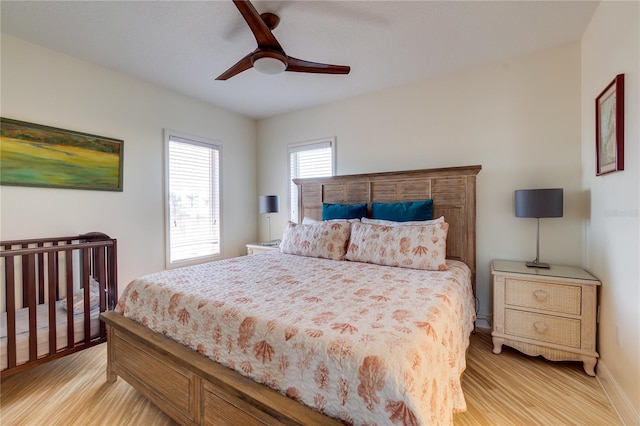 bedroom with light wood-style flooring, baseboards, and ceiling fan