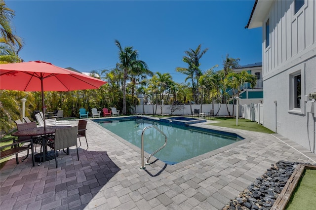 view of pool featuring a pool with connected hot tub, a fenced backyard, and a patio