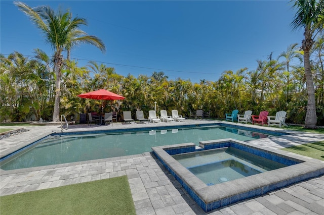 outdoor pool with a patio and an in ground hot tub