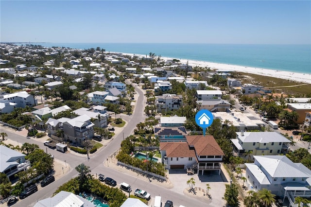 drone / aerial view with a beach view, a residential view, and a water view
