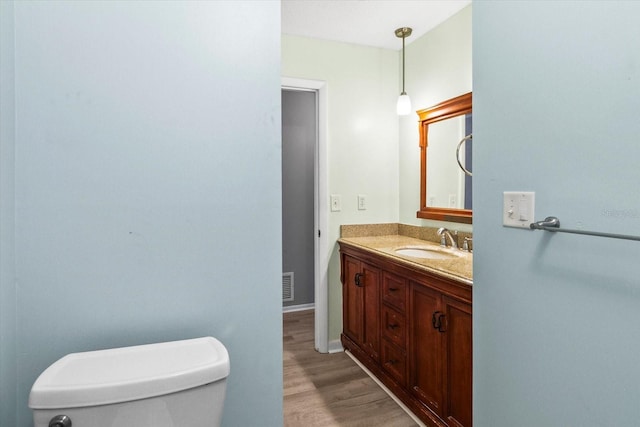 2961 Valencia Rd, Venice, FL 34293 - half bathroom featuring toilet, vanity, wood finished floors, and visible vents