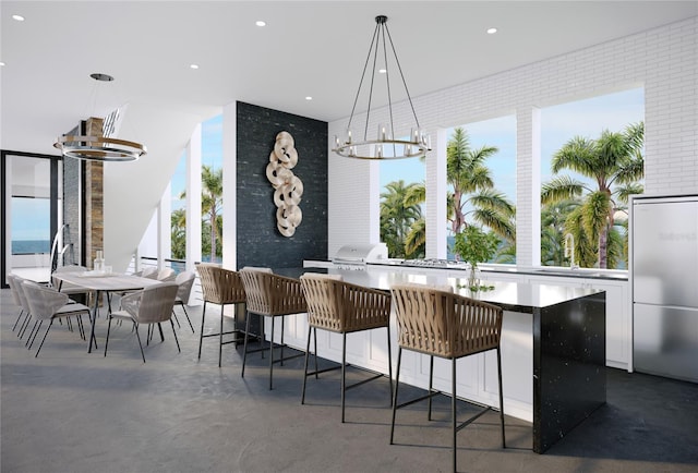 4050 Higel Ave, Sarasota, FL 34242 - bar with hanging light fixtures, an inviting chandelier, finished concrete flooring, a sink, and stainless steel built in refrigerator