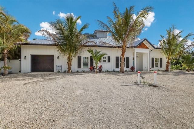 305 73rd St, Holmes Beach, FL 34217 - view of front facade featuring a garage, board and batten siding, and gravel driveway