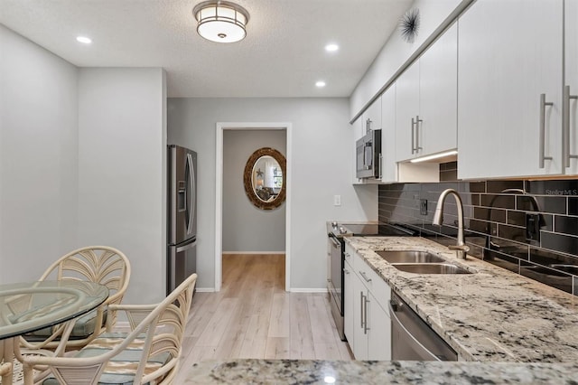 4169 66th Street Cir W Unit 4169, Bradenton, FL 34209 - kitchen with appliances with stainless steel finishes, a sink, light stone counters, tasteful backsplash, and baseboards