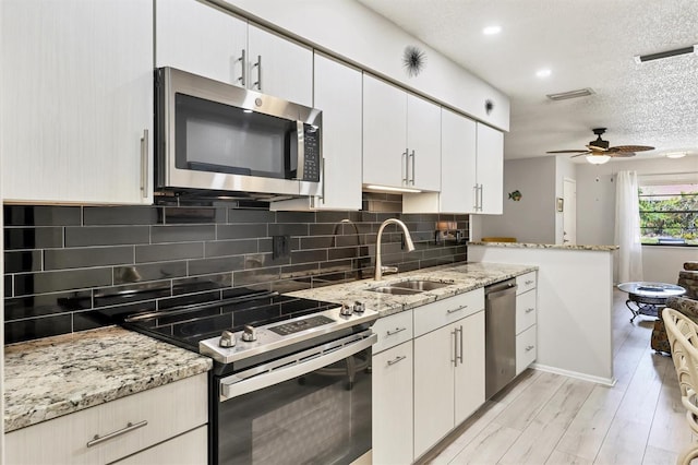 4169 66th Street Cir W Unit 4169, Bradenton, FL 34209 - kitchen with stainless steel appliances, a sink, tasteful backsplash, light wood-style flooring, and a ceiling fan