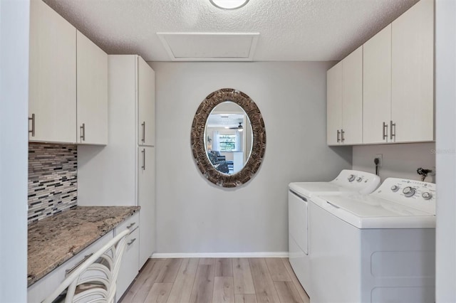 4169 66th Street Cir W Unit 4169, Bradenton, FL 34209 - washroom with cabinet space, separate washer and dryer, light wood-style flooring, a textured ceiling, and baseboards