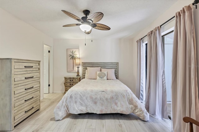 4169 66th Street Cir W Unit 4169, Bradenton, FL 34209 - bedroom with light wood finished floors, a ceiling fan, baseboards, and a textured ceiling