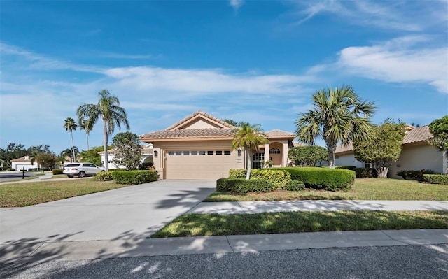 3835 Alamanda Dr, Sarasota, FL 34238 - view of front of property with a garage, a tile roof, stucco siding, concrete driveway, and a front yard