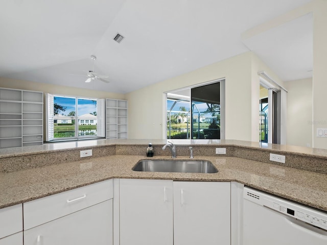 3835 Alamanda Dr, Sarasota, FL 34238 - kitchen featuring white dishwasher, a sink, light stone counters, ceiling fan, and white cabinetry