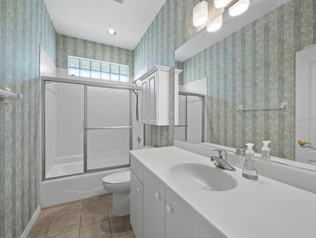 3835 Alamanda Dr, Sarasota, FL 34238 - bathroom with wallpapered walls, toilet, vanity, tile patterned flooring, and combined bath / shower with glass door
