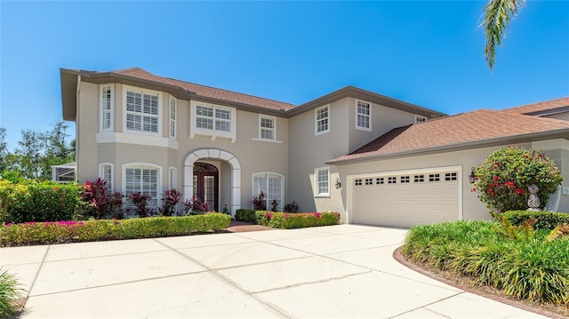 view of front of property featuring an attached garage, stucco siding, and concrete driveway