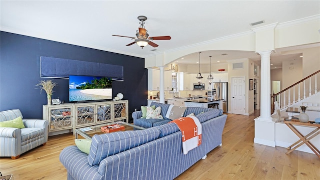 living room featuring crown molding, ornate columns, ceiling fan, and visible vents