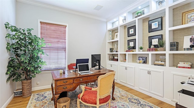 office area featuring light wood-style floors, baseboards, ornamental molding, and built in shelves