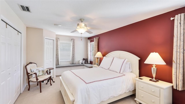 bedroom featuring light colored carpet, ceiling fan, and visible vents