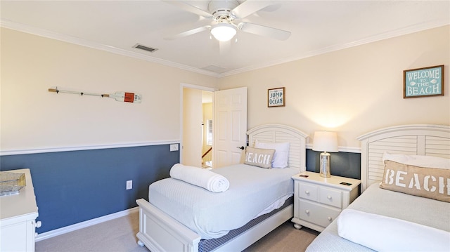 carpeted bedroom with visible vents, ornamental molding, baseboards, and a ceiling fan