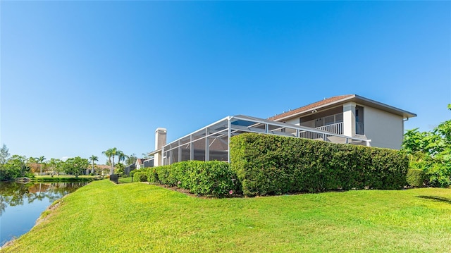 view of yard featuring a water view and glass enclosure