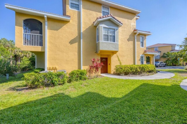 mediterranean / spanish-style house featuring a front lawn and stucco siding