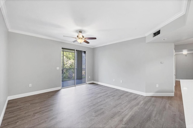 spare room with a ceiling fan, wood finished floors, baseboards, and crown molding