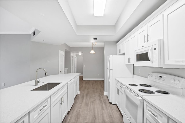 kitchen with white appliances, a sink, light countertops, and light wood-style flooring