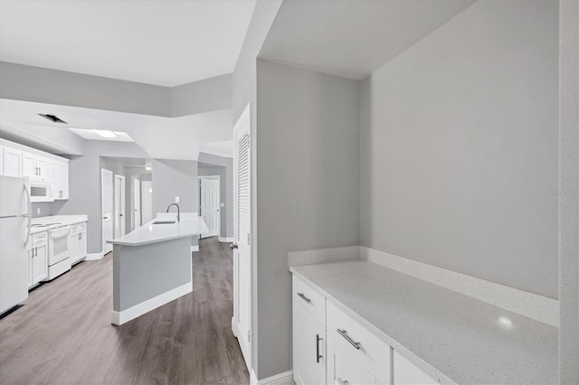 bathroom featuring wood finished floors, baseboards, and a sink