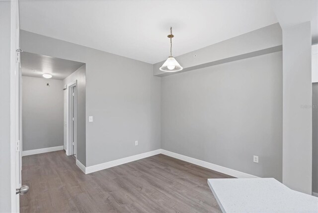 spare room featuring wood finished floors and baseboards