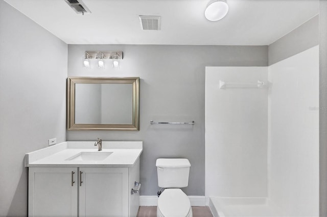 full bath with toilet, tiled shower, vanity, and baseboards