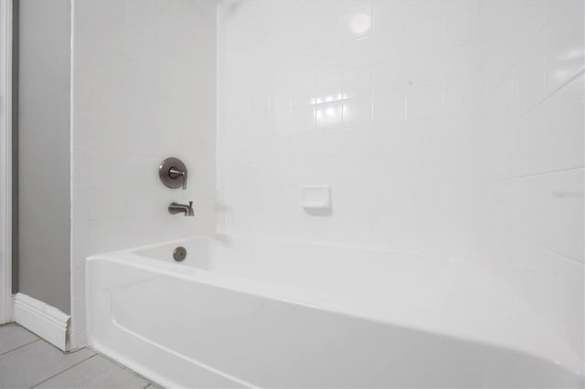 bathroom featuring tile patterned flooring, a bathtub, and baseboards