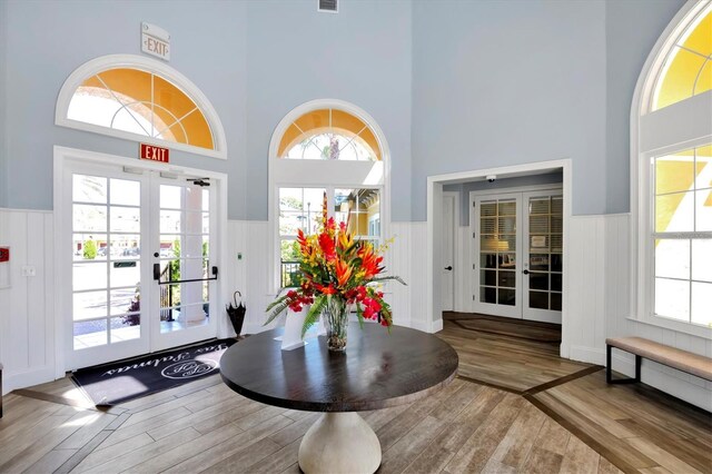 building lobby with a wainscoted wall, a towering ceiling, and a decorative wall