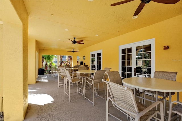 view of patio with outdoor dining area and a ceiling fan