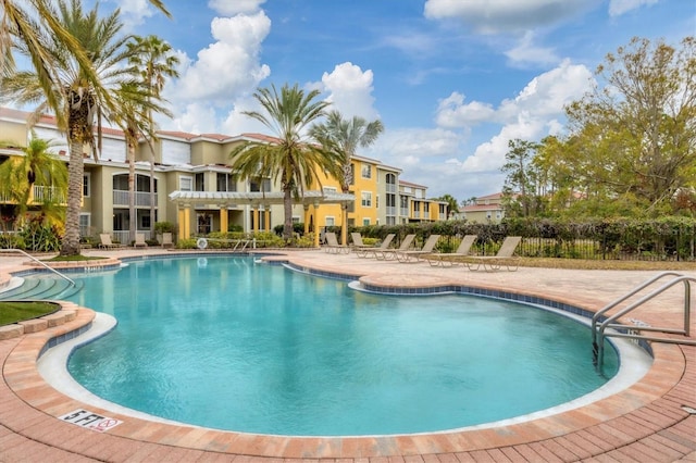 community pool featuring a patio and fence