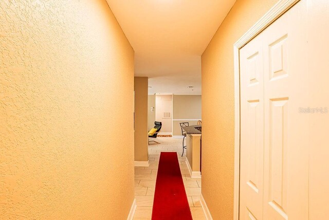 4061 Crockers Lake Blvd Unit 2618, Sarasota, FL 34238 - hallway featuring light tile patterned flooring, a textured wall, and baseboards