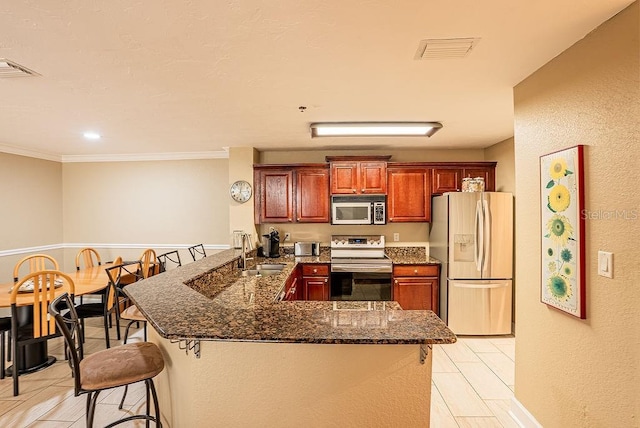 4061 Crockers Lake Blvd Unit 2618, Sarasota, FL 34238 - kitchen featuring a breakfast bar, visible vents, a sink, a peninsula, and appliances with stainless steel finishes