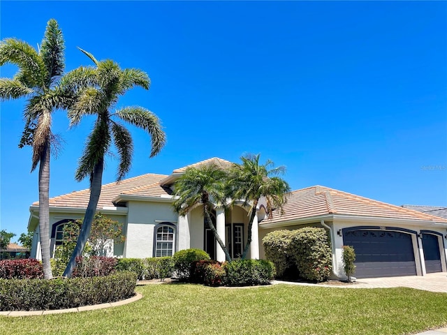 2980 Seasons Blvd, Sarasota, FL 34240 - view of front of home with a tile roof, stucco siding, a front lawn, and an attached garage