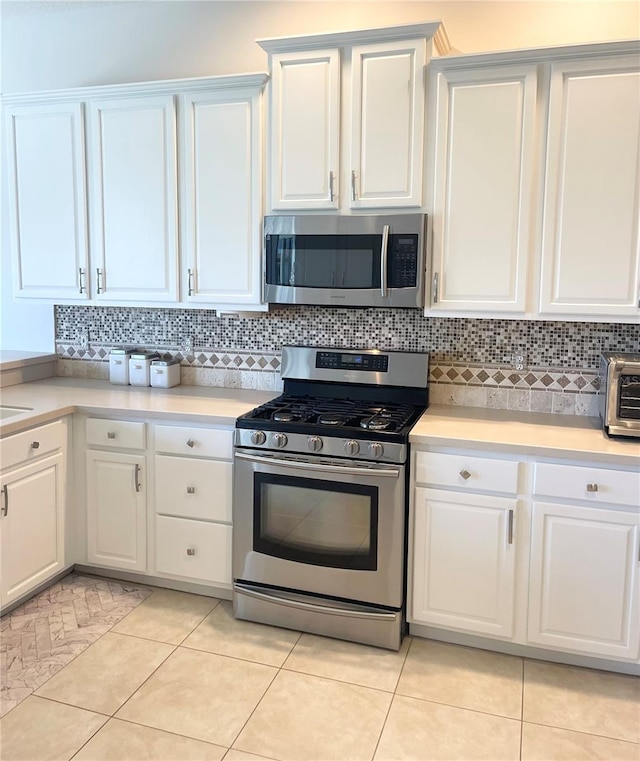 2980 Seasons Blvd, Sarasota, FL 34240 - kitchen with stainless steel appliances, light countertops, white cabinets, and backsplash