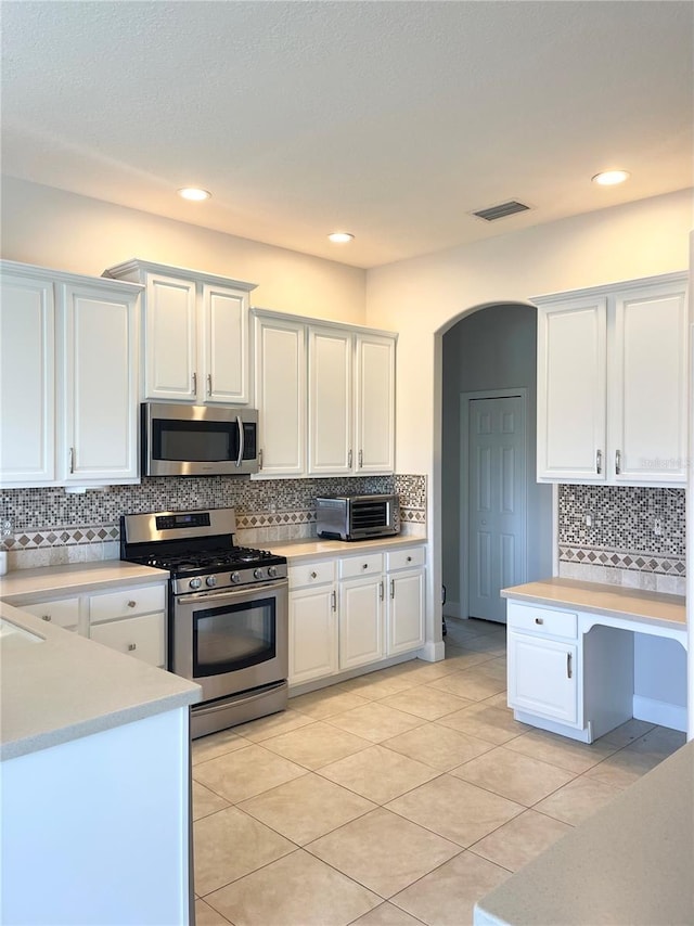 2980 Seasons Blvd, Sarasota, FL 34240 - kitchen featuring appliances with stainless steel finishes, light countertops, white cabinetry, tasteful backsplash, and recessed lighting