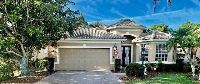 9120 Willow Brook Dr, Sarasota, FL 34238 - mediterranean / spanish-style house featuring stucco siding, an attached garage, a tiled roof, and driveway