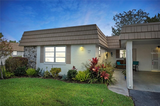 5521 Riverbluff Cir Unit V-10, Sarasota, FL 34231 - view of front facade featuring mansard roof, stucco siding, and a front yard