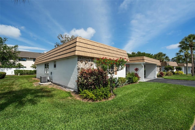 5521 Riverbluff Cir Unit V-10, Sarasota, FL 34231 - view of side of property with mansard roof, cooling unit, a lawn, and stone siding