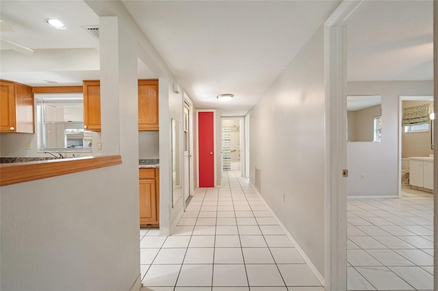 5521 Riverbluff Cir Unit V-10, Sarasota, FL 34231 - hallway with light tile patterned flooring, plenty of natural light, and baseboards