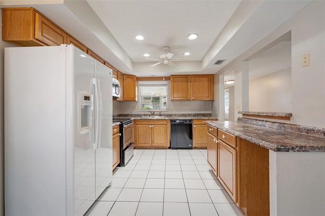 5521 Riverbluff Cir Unit V-10, Sarasota, FL 34231 - kitchen with stainless steel appliances, a ceiling fan, recessed lighting, a sink, and dark stone counters