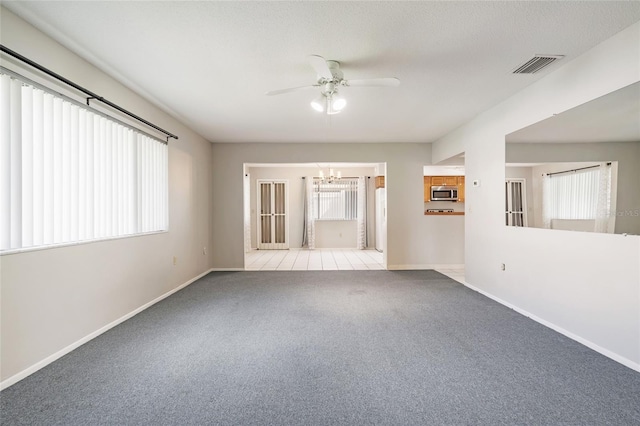 5521 Riverbluff Cir Unit V-10, Sarasota, FL 34231 - carpeted empty room featuring a ceiling fan, a chandelier, healthy amount of natural light, and baseboards