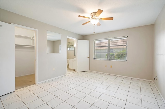 5521 Riverbluff Cir Unit V-10, Sarasota, FL 34231 - unfurnished bedroom with a walk in closet, a closet, baseboards, and a ceiling fan