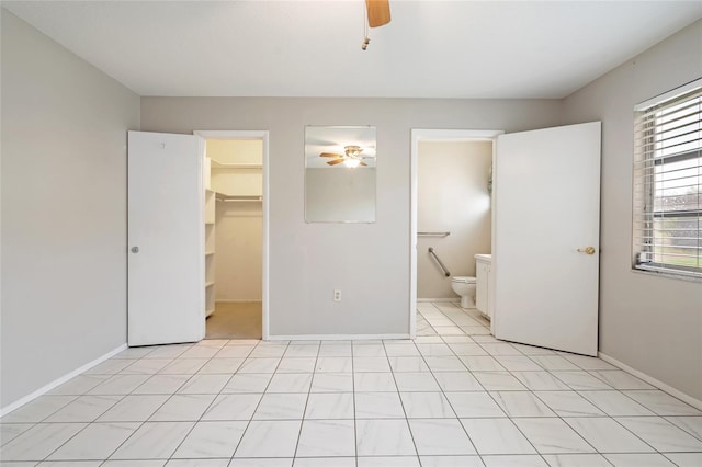 5521 Riverbluff Cir Unit V-10, Sarasota, FL 34231 - unfurnished bedroom featuring a spacious closet, ceiling fan, a closet, and baseboards