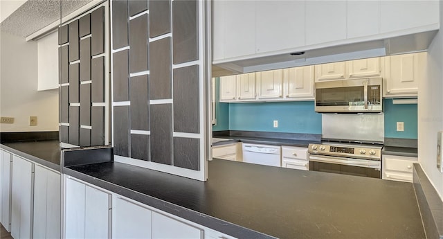 6157 Midnight Pass Rd Unit B42, Sarasota, FL 34242 - kitchen with dark countertops, appliances with stainless steel finishes, a textured ceiling, and white cabinets