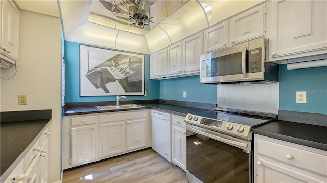 6157 Midnight Pass Rd Unit B42, Sarasota, FL 34242 - kitchen with dark countertops, appliances with stainless steel finishes, a sink, and white cabinetry
