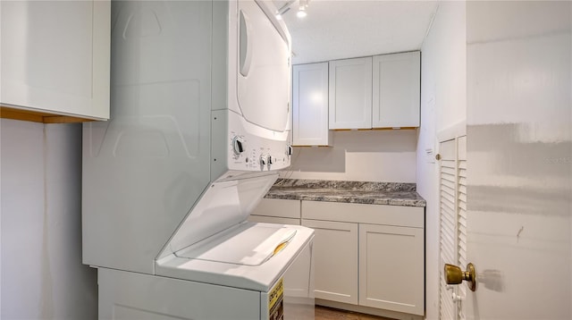 6157 Midnight Pass Rd Unit B42, Sarasota, FL 34242 - clothes washing area featuring stacked washer and clothes dryer and cabinet space