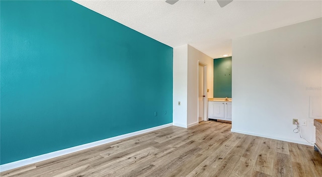 6157 Midnight Pass Rd Unit B42, Sarasota, FL 34242 - empty room with wood finished floors, a textured ceiling, baseboards, and ceiling fan