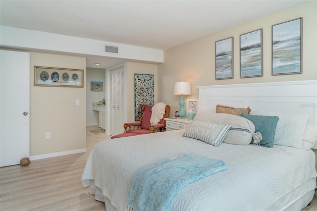 3609 57th Avenue Dr W Unit 37, Bradenton, FL 34210 - bedroom featuring wood finished floors, ensuite bath, and a textured ceiling