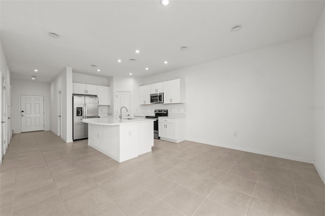 8596 Lunar Skye St, Sarasota, FL 34241 - kitchen featuring a sink, a kitchen island with sink, white cabinets, appliances with stainless steel finishes, and recessed lighting